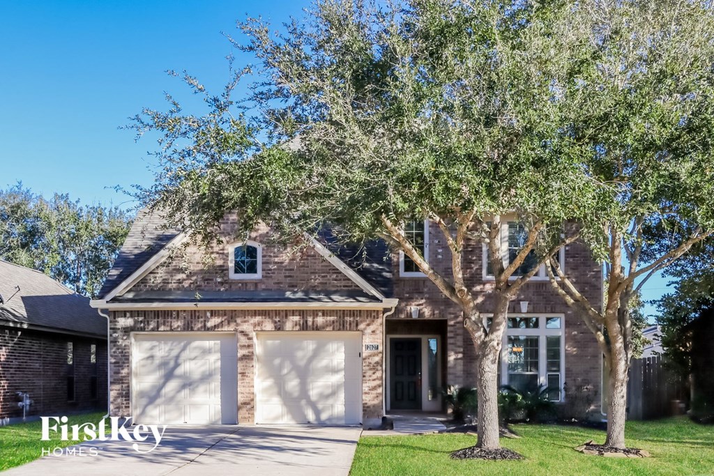 a brick house with two trees in front of it