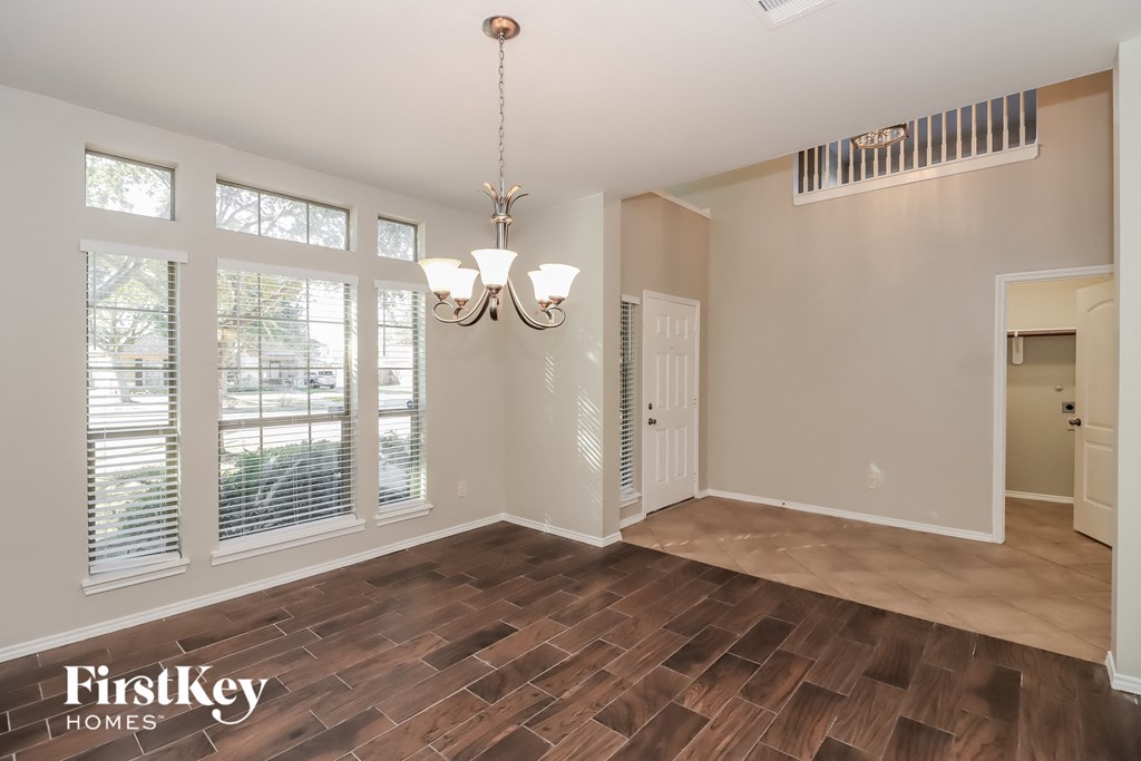 an empty living room with a large window and wood flooring