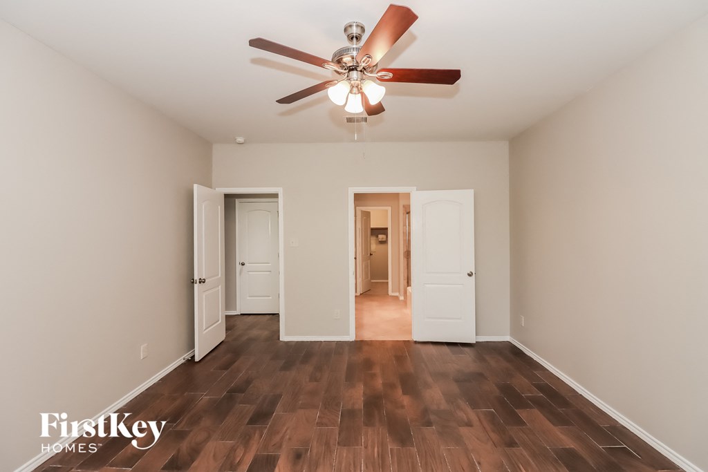 a living room with a ceiling fan and wood floors