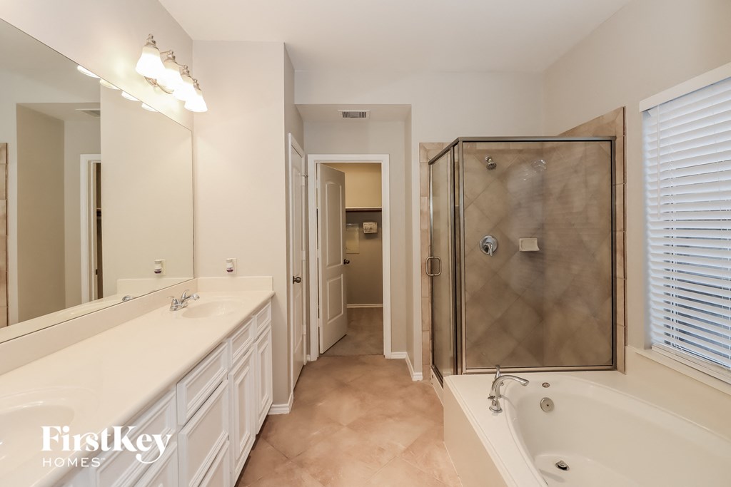 a bathroom with a tub and a shower and a sink