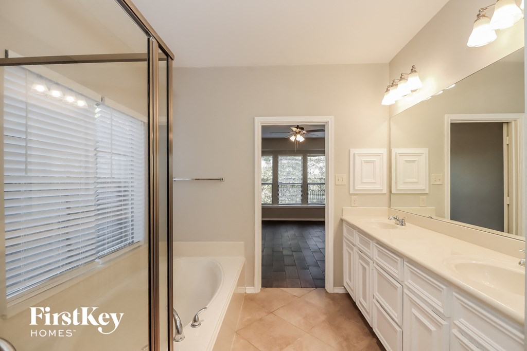 a bathroom with a tub and a sink and a shower