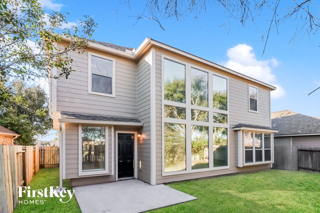 the exterior of a house with large windows and a concrete driveway