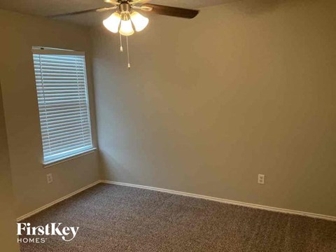 a bedroom with a ceiling fan and a window