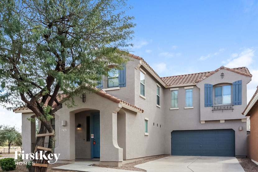 A house with a blue door and a tree in front of it.