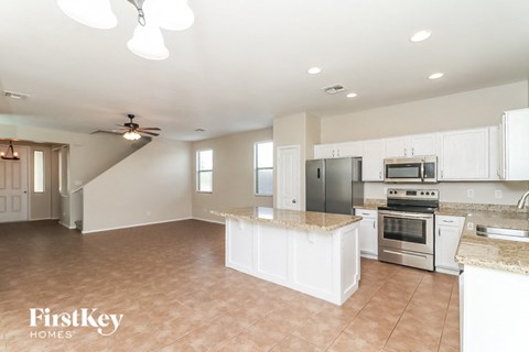 A kitchen with a stove top oven and a refrigerator.