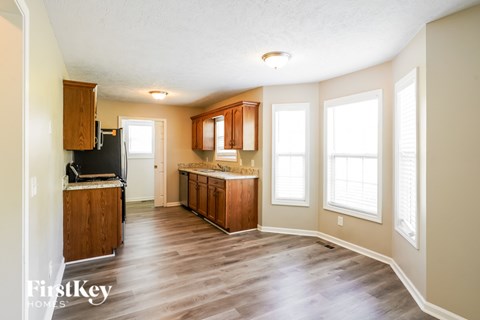 A kitchen with wooden cabinets and a refrigerator.