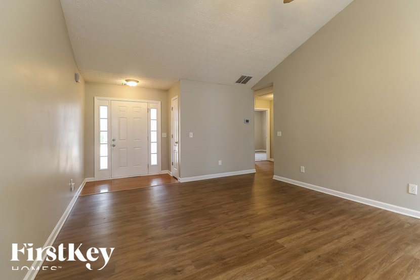 A room with wooden floors and two doors.