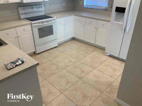 A kitchen with white appliances and cabinets.