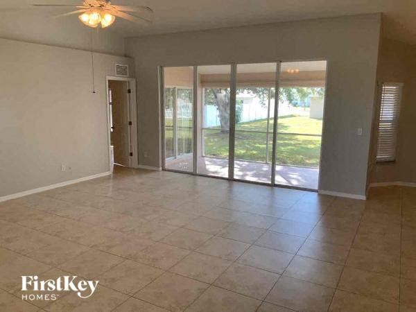 A spacious room with a sliding glass door leading to a backyard.