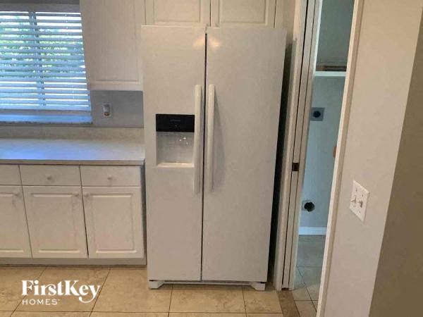 A white refrigerator with a water dispenser on the door.