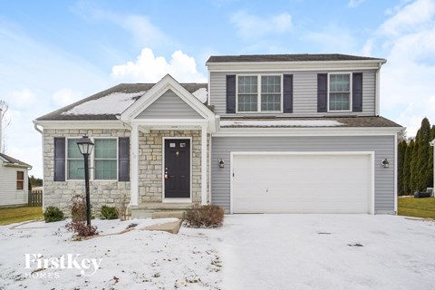 a white brick house with a garage door in the snow