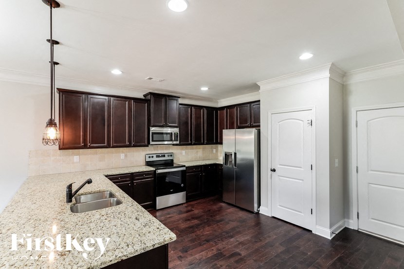 A kitchen with dark brown cabinets and a stainless steel refrigerator.
