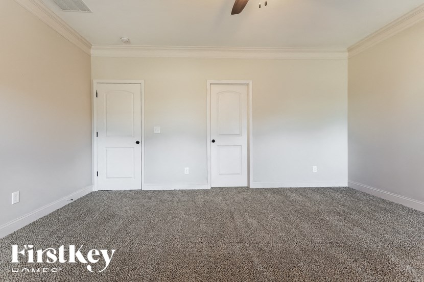 A room with two doors and a carpeted floor.