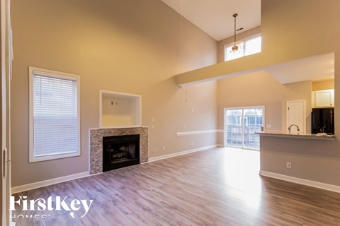 A spacious living room with a fireplace and wooden floors.