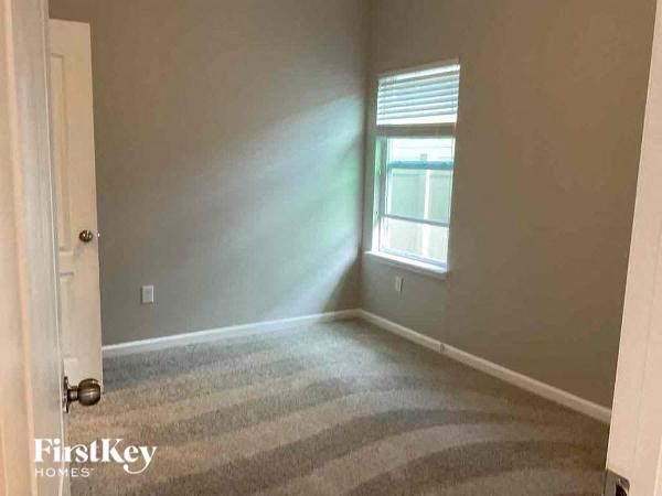 an empty room with a window and a carpet