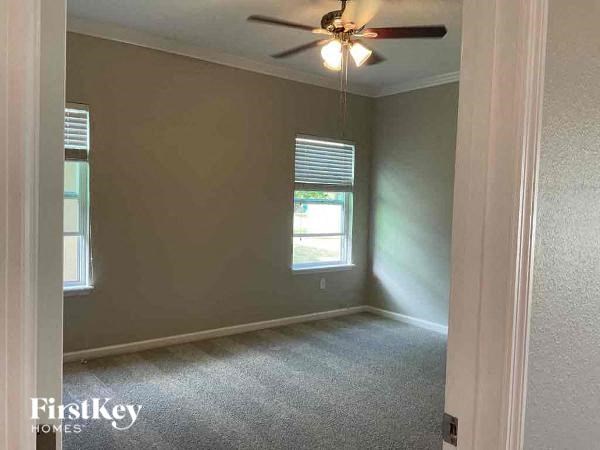 an empty room with a ceiling fan and a window