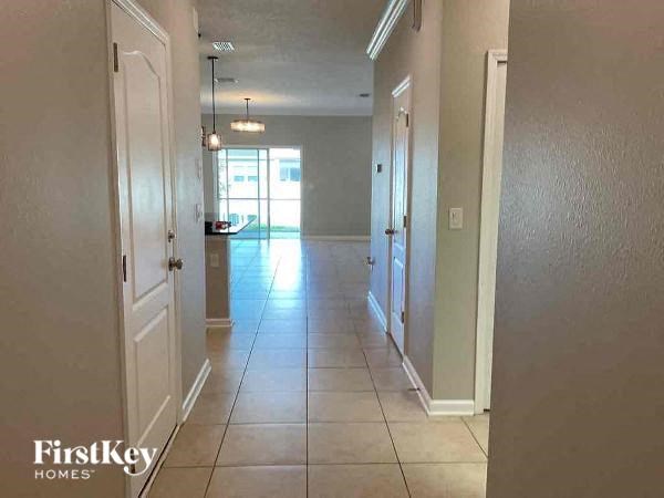 a hallway with a tiled floor and an empty house