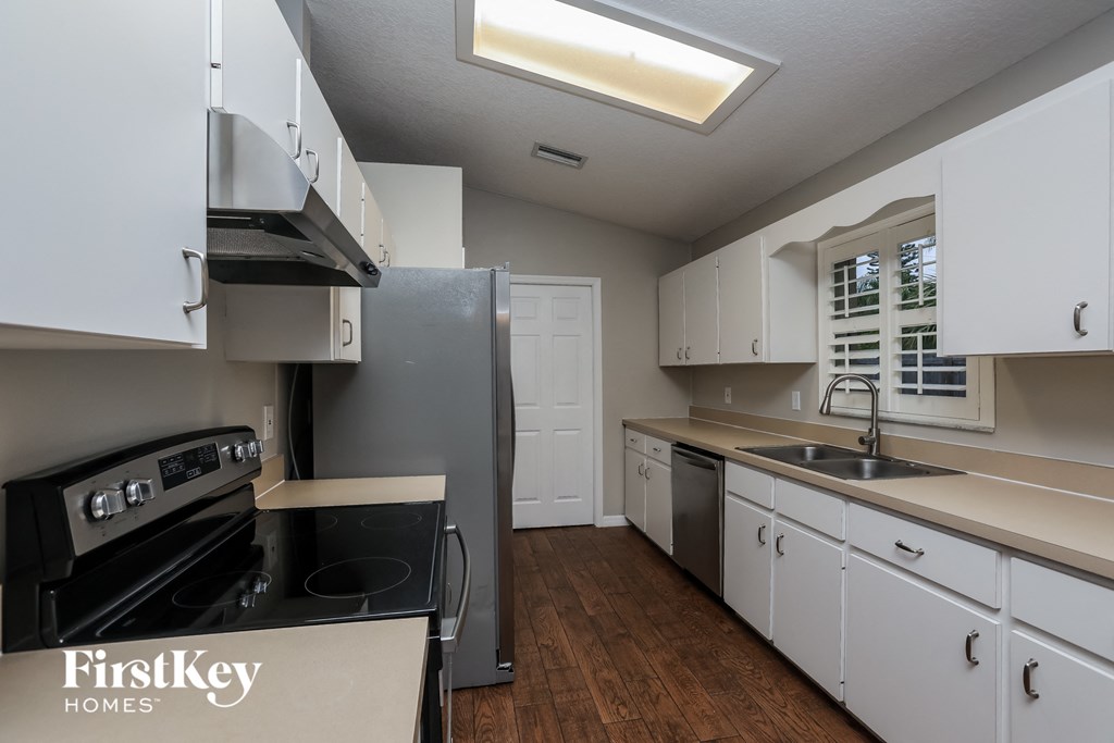 a kitchen with white cabinets and stainless steel appliances