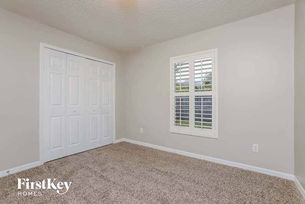 a bedroom with a carpeted floor and a white door