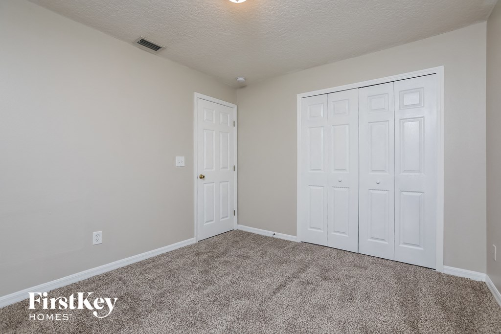 a bedroom with two closets and a carpeted floor