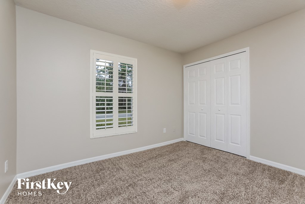 a bedroom with carpet and a white door