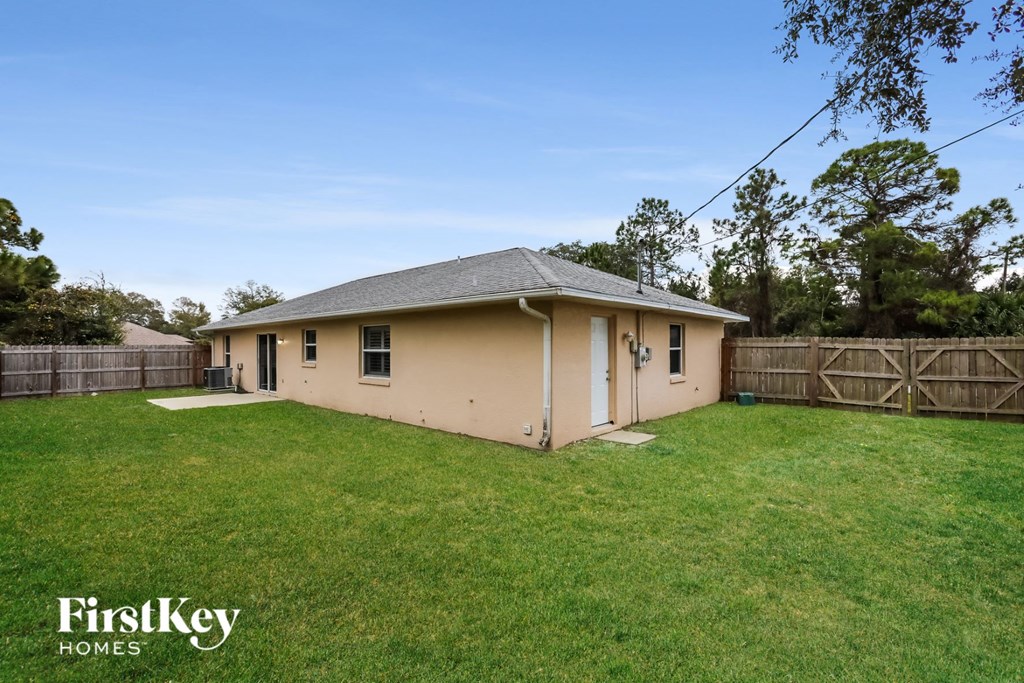 a backyard with a house and a grassy yard