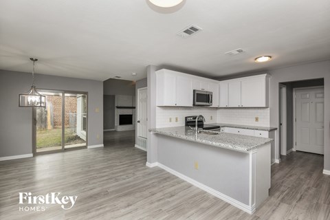 a kitchen with white cabinets and a granite counter top