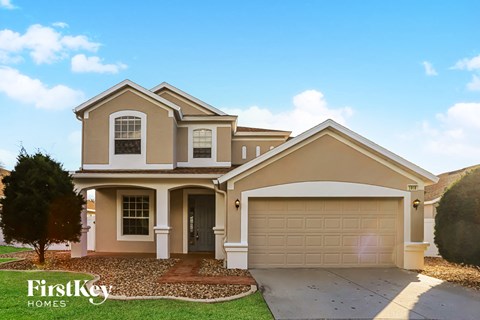 a beige house with a garage and a driveway