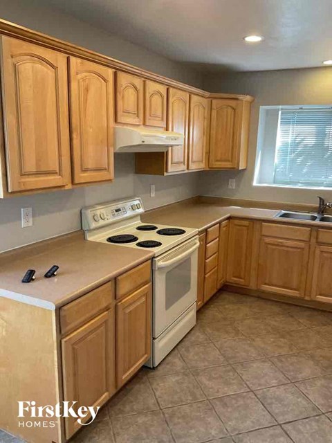 a kitchen with wooden cabinets and a white stove top oven