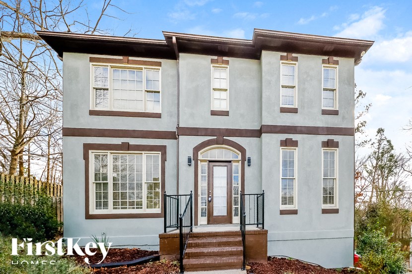the front of a white house with stairs and a door