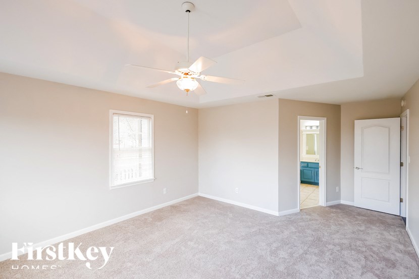 a bedroom with a carpeted floor and a ceiling fan