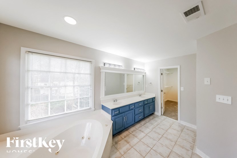 a blue and white bathroom with a tub and a sink