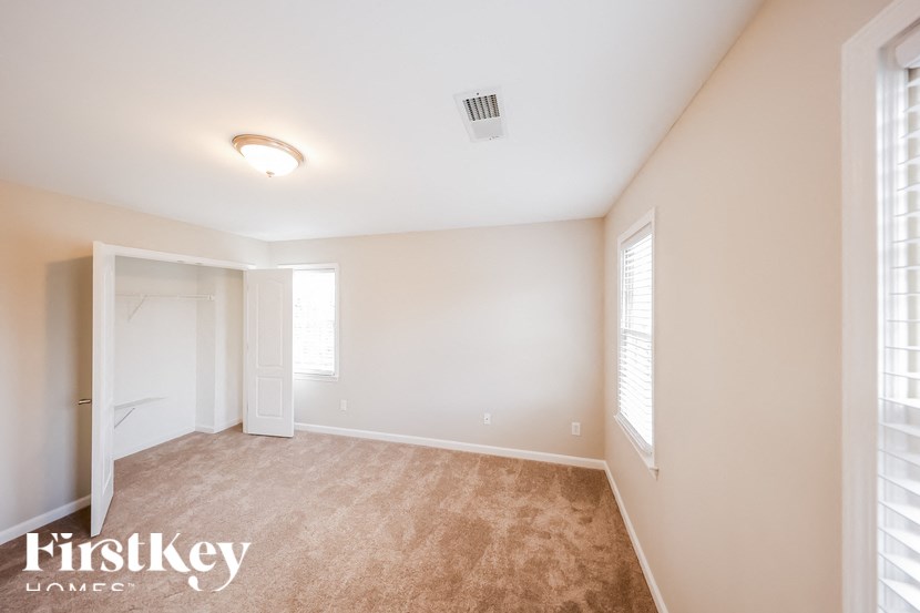 a bedroom with a carpeted floor and a door to a closet