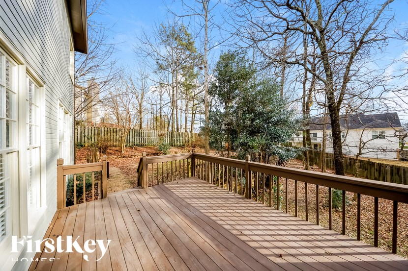 a deck with a view of a body of water and trees
