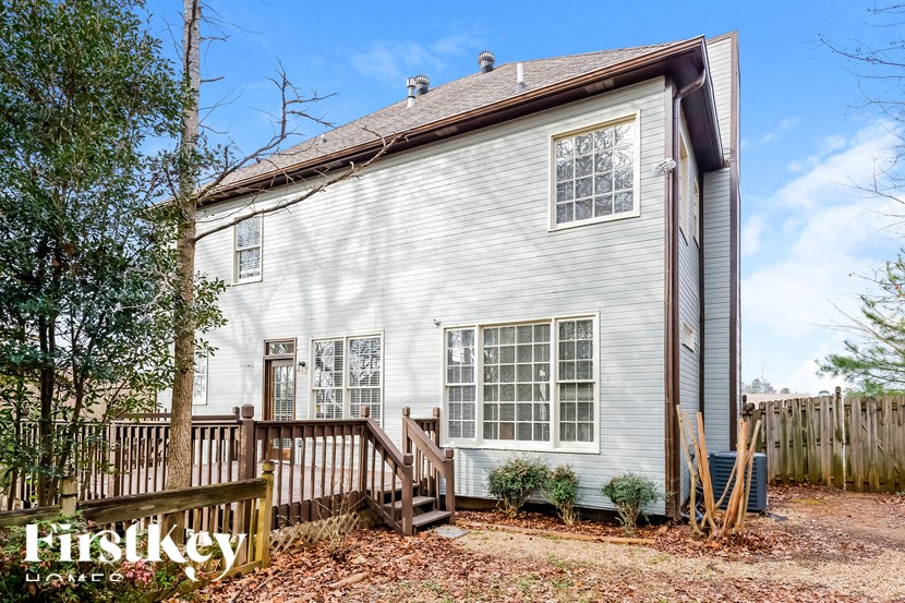 the outside of a white house with a wooden fence