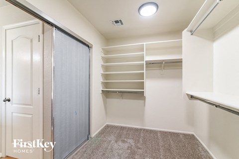 A bedroom with a closet and a carpeted floor.