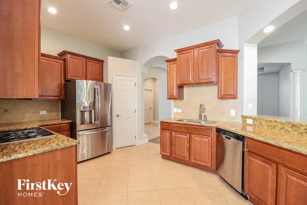 a large kitchen with wooden cabinets and stainless steel appliances