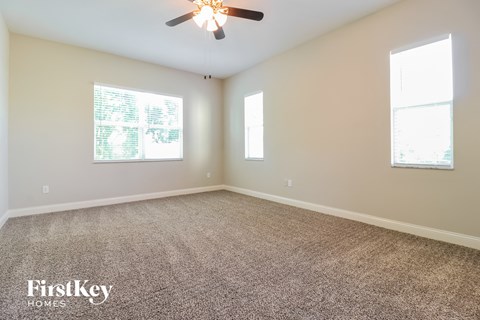 a living room with carpet and a ceiling fan