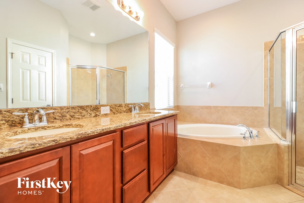 a bathroom with a tub and a sink and a mirror