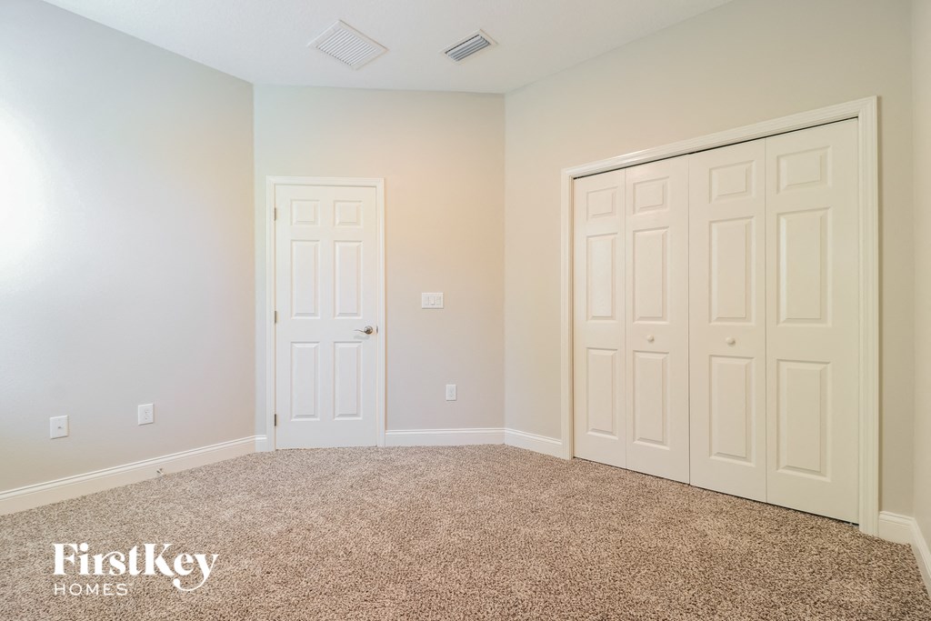a bedroom with two closet doors and a carpeted floor