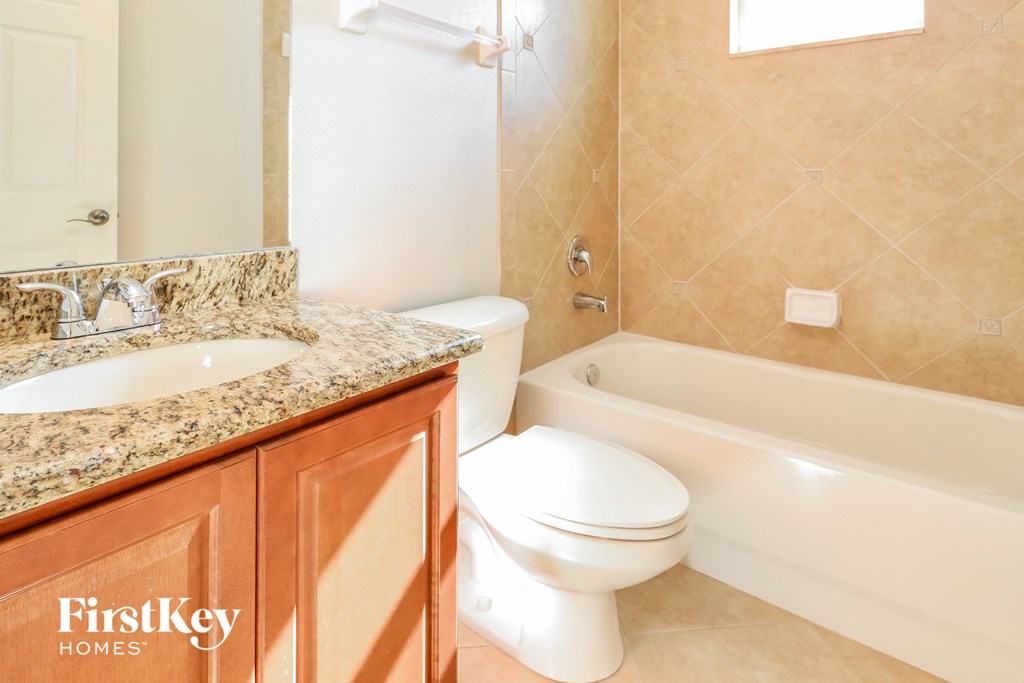 a bathroom with a toilet and a sink and a bath tub