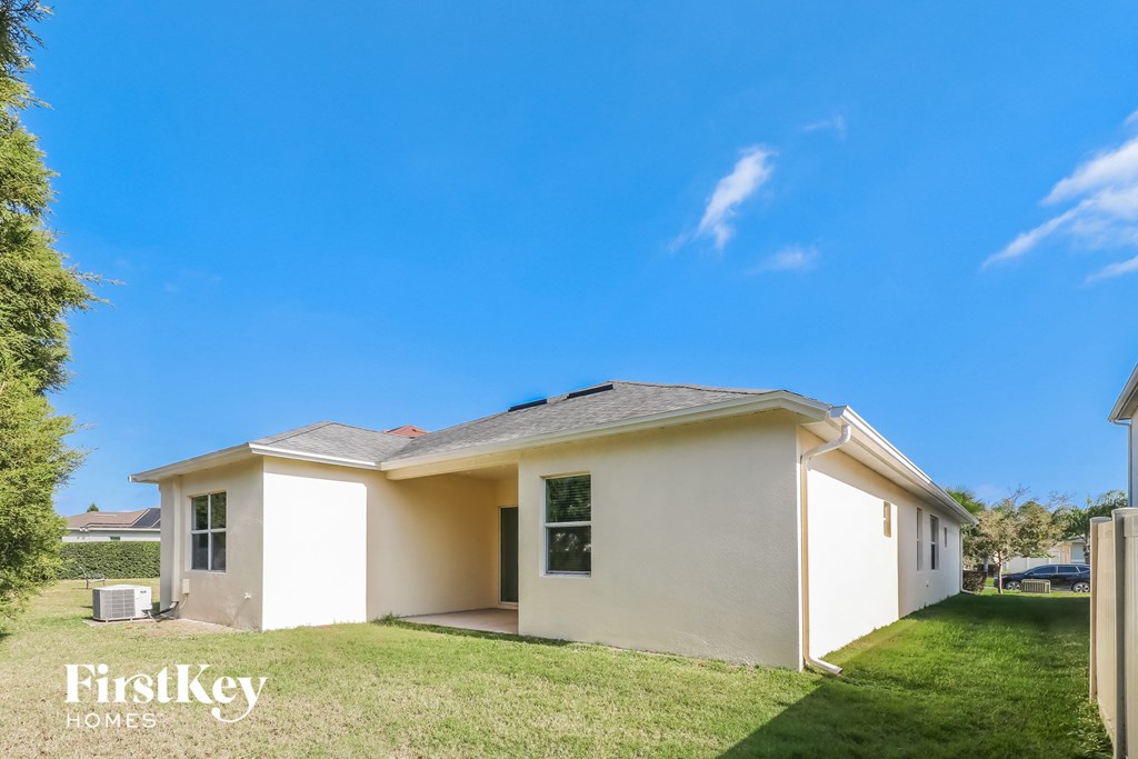 a small white house with a lawn and a blue sky