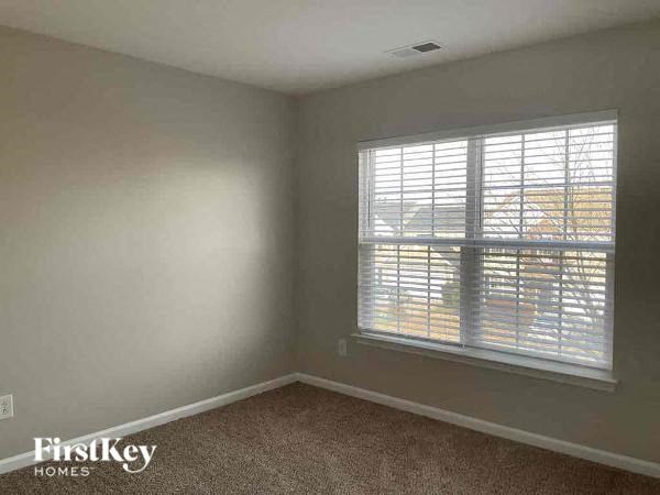 an empty room with a window and a carpet