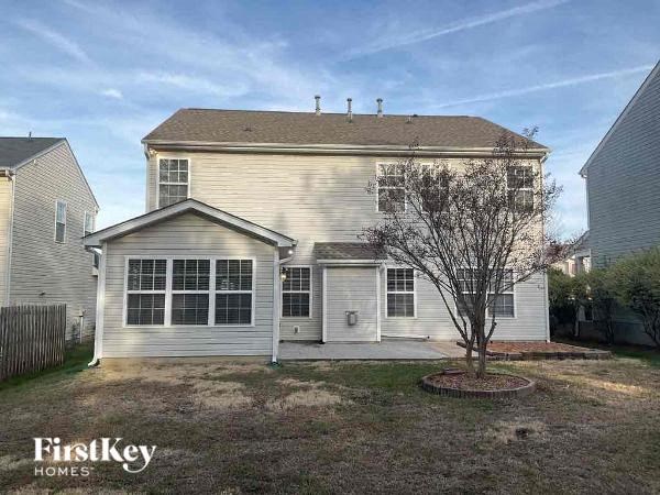 a white house with a tree in the yard