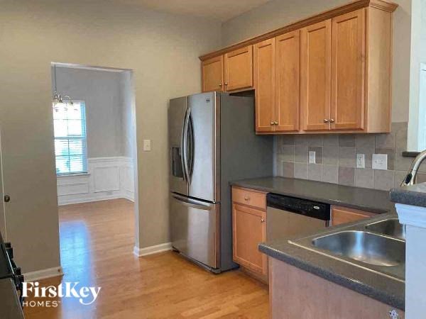 a kitchen with wooden cabinets and a stainless steel refrigerator