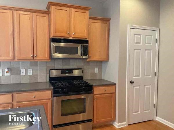 a kitchen with stainless steel appliances and wooden cabinets