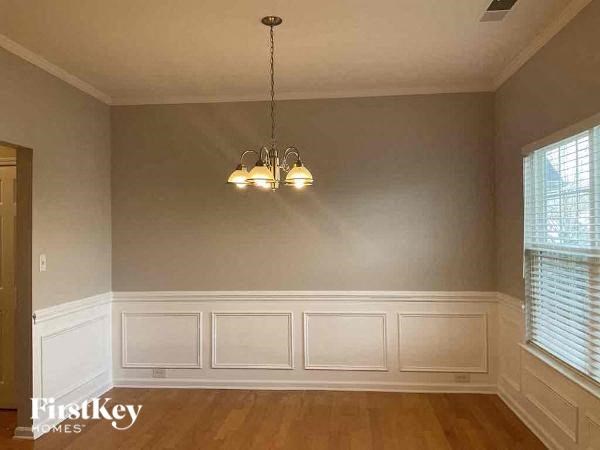 a dining room with a chandelier and white walls