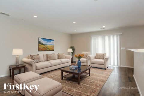 A living room with a painting on the wall and a couch with pillows.