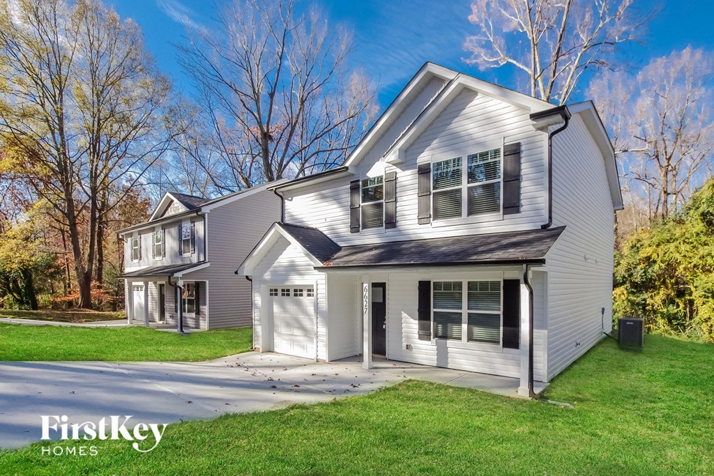 a white house with a garage and a lawn