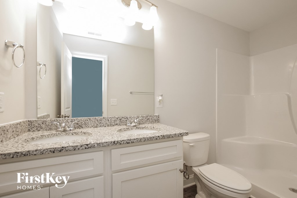 a white bathroom with two sinks and a toilet